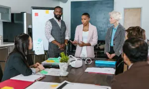 Equipo discutiendo estrategias para atraer inversores para empresas. Reunión de negocios con pizarra y documentos sobre la mesa.