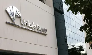 Fachada de Unicaja Banco con su logo metálico. Las reseñas sobre este banco son variadas, pero la imagen muestra su presencia física.