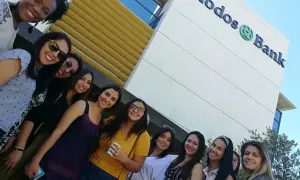 Grupo de amigas sonriendo frente al edificio de Triodos Bank. Sus opiniones sobre el banco son positivas.