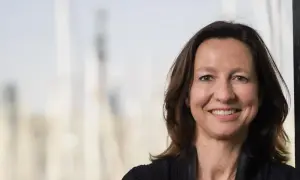 Helena Torras, una mujer sonriente con cabello castaño, posa para un retrato profesional.
