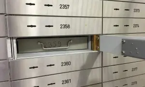 Una fila de casilleros de seguridad de banco. El casillero 2359 está parcialmente abierto, mostrando una caja metálica con un asa.