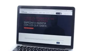 Un portátil muestra la web de myinvestor, invitando a invertir. La cartera metal myinvestor es una opción para gestionar tus finanzas.