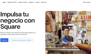 Una mujer sonríe mientras acepta un pago con tarjeta en su tienda, mostrando cómo Square facilita el web e-commerce y las ventas en persona.