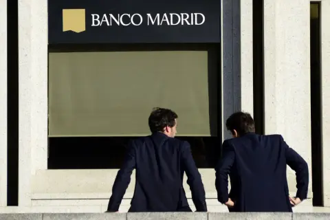 Dos hombres de traje observan la fachada de Banco Madrid. ¿Qué opiniones tendrán sobre sus servicios?