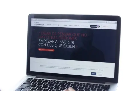 Un portátil muestra la web de myinvestor, invitando a invertir. La cartera metal myinvestor es una opción para gestionar tus finanzas.