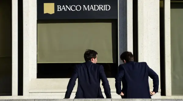 Dos hombres de traje observan la fachada de Banco Madrid. ¿Qué opiniones tendrán sobre sus servicios?