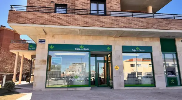 Fachada de Caja rural de Soria con su logo verde y blanco. Se ve un cajero automático y un cartel de "Camino de los Royales".