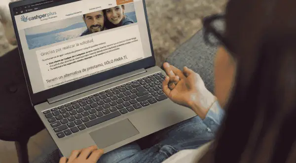 Laptop muestra web de Cashperplus con mensaje de agradecimiento. Buscando "cashperplus opiniones" para tomar una decisión.