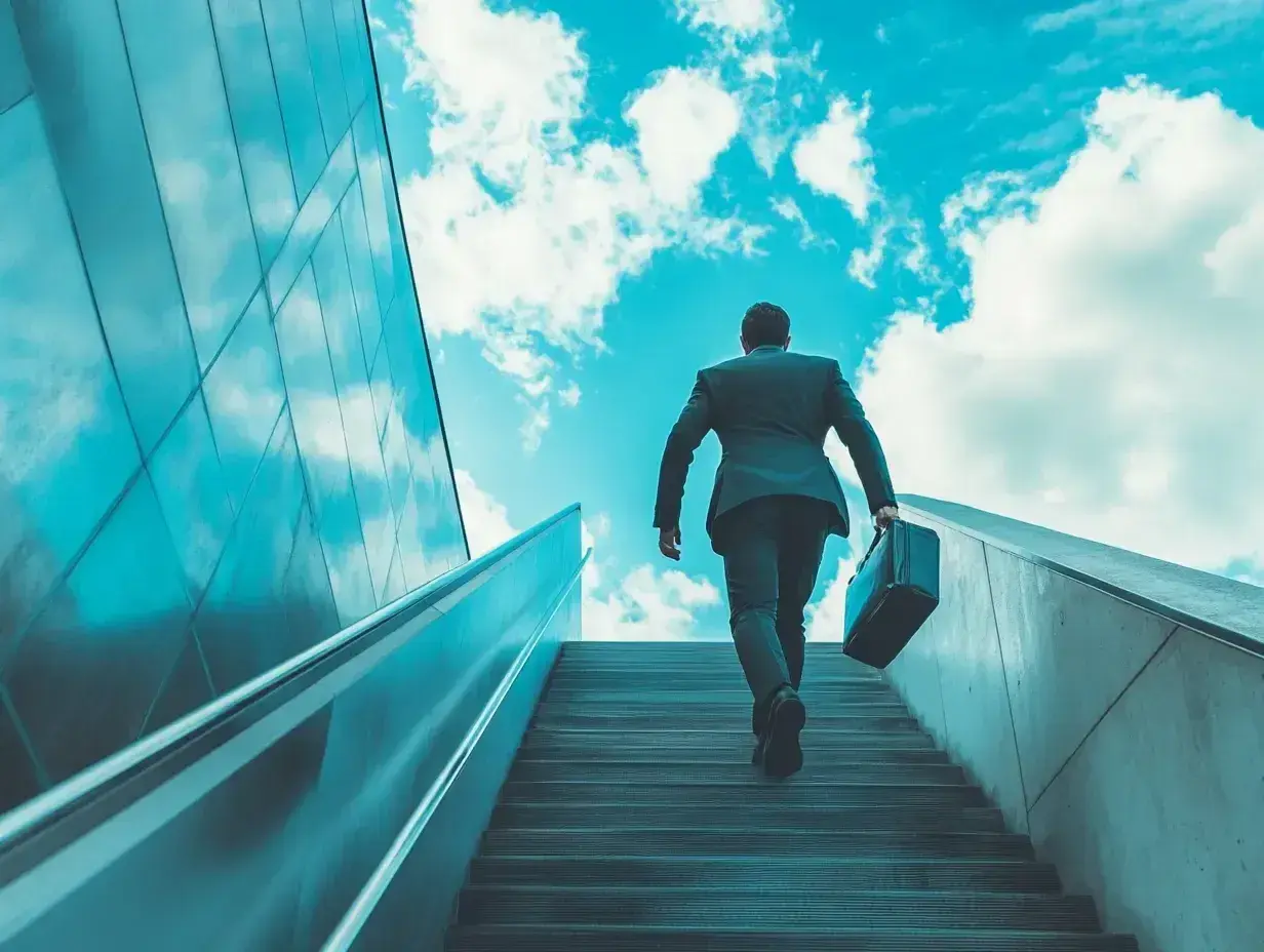Hombre con maletín subiendo escaleras hacia el cielo azul, simbolizando un modelo de negocio escalable y el éxito.