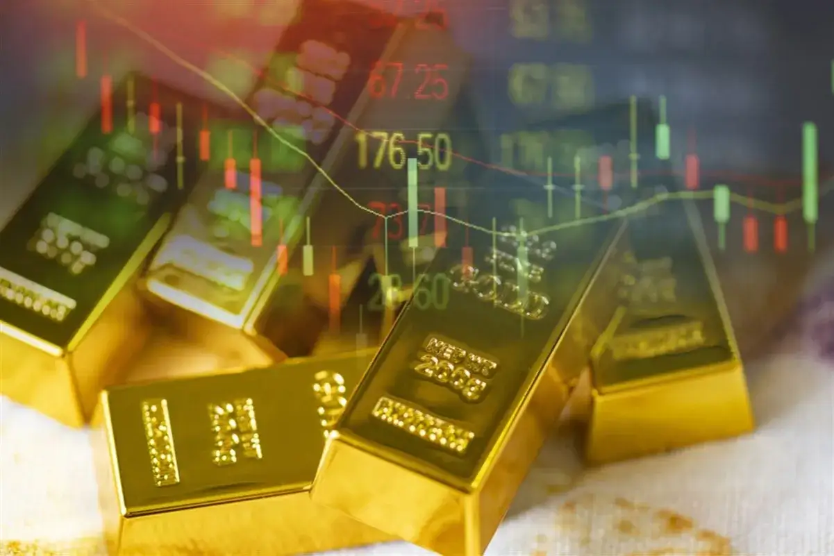 Lingotes de oro apilados con gráficos bursátiles superpuestos, sugiriendo cómo comprar oro en bolsa.