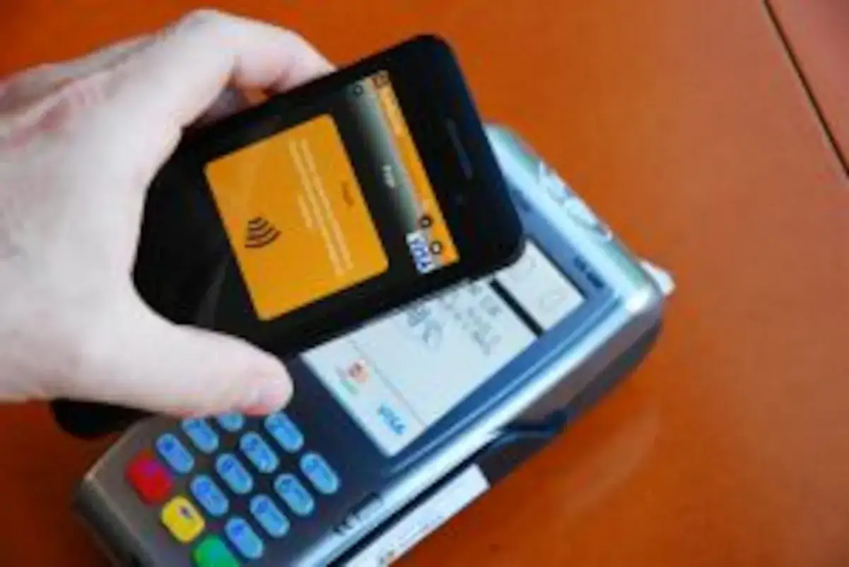 Pago móvil con smartphone sobre terminal. Las reseñas de Bankinter destacan la facilidad de uso.