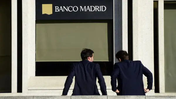 Dos hombres de traje observan la fachada de Banco Madrid. ¿Qué opiniones tendrán sobre sus servicios?