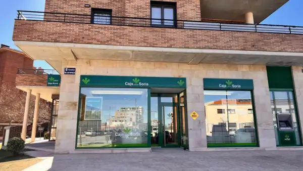 Fachada de Caja rural de Soria con su logo verde y blanco. Se ve un cajero automático y un cartel de "Camino de los Royales".