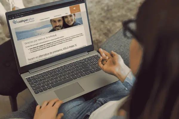 Laptop muestra web de Cashperplus con mensaje de agradecimiento. Buscando "cashperplus opiniones" para tomar una decisión.