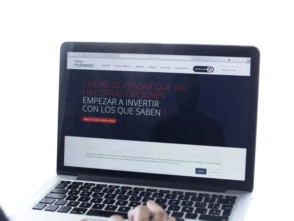 Un portátil muestra la web de myinvestor, invitando a invertir. La cartera metal myinvestor es una opción para gestionar tus finanzas.